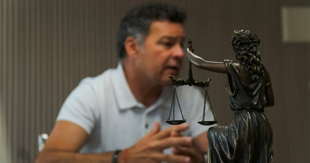 Conversation juridique avec statue symbolique de la justice en premier plan